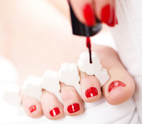Applying nail polish to toes